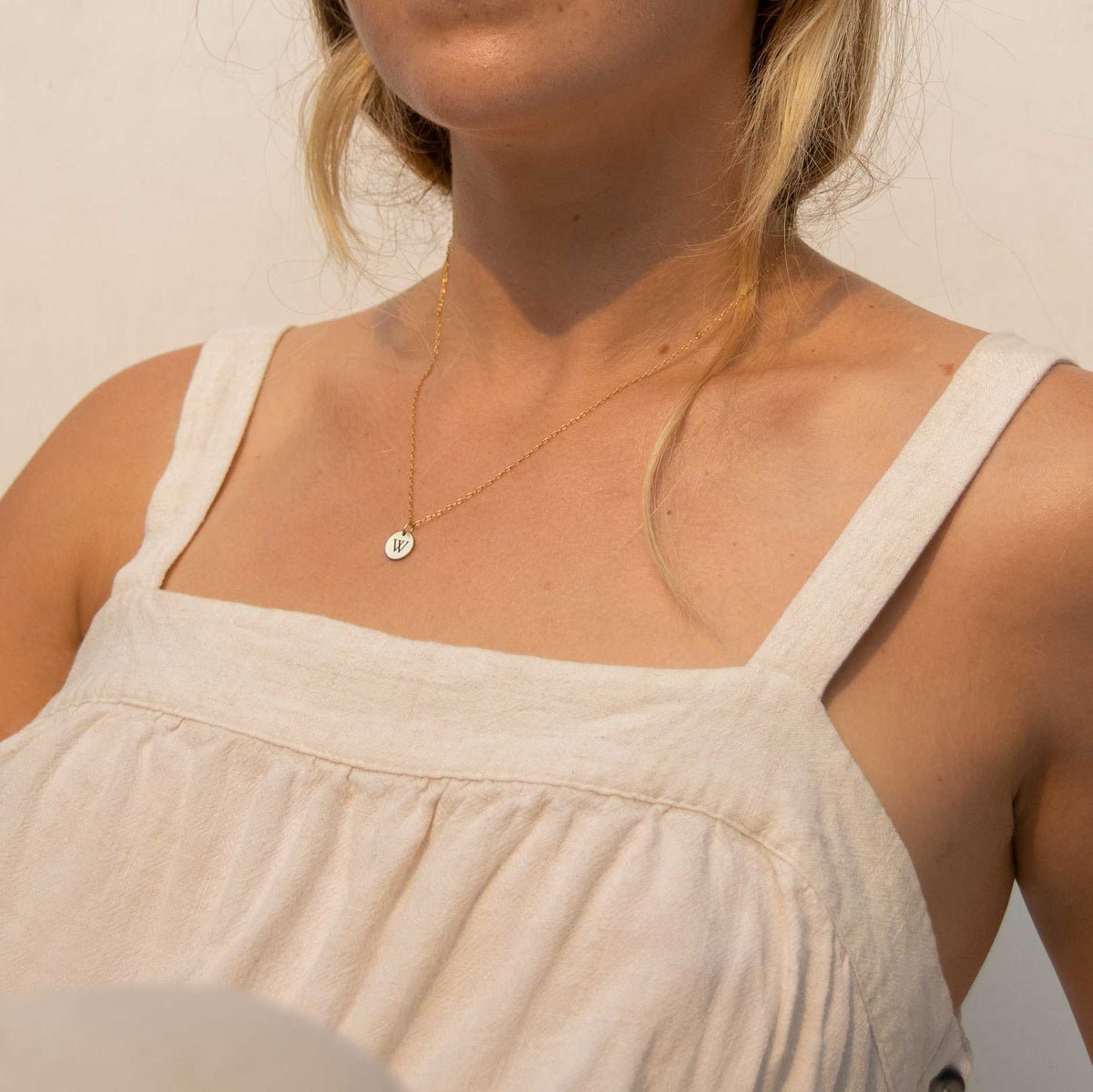 A woman wearing the 10mm circle necklace while reclining backwards.