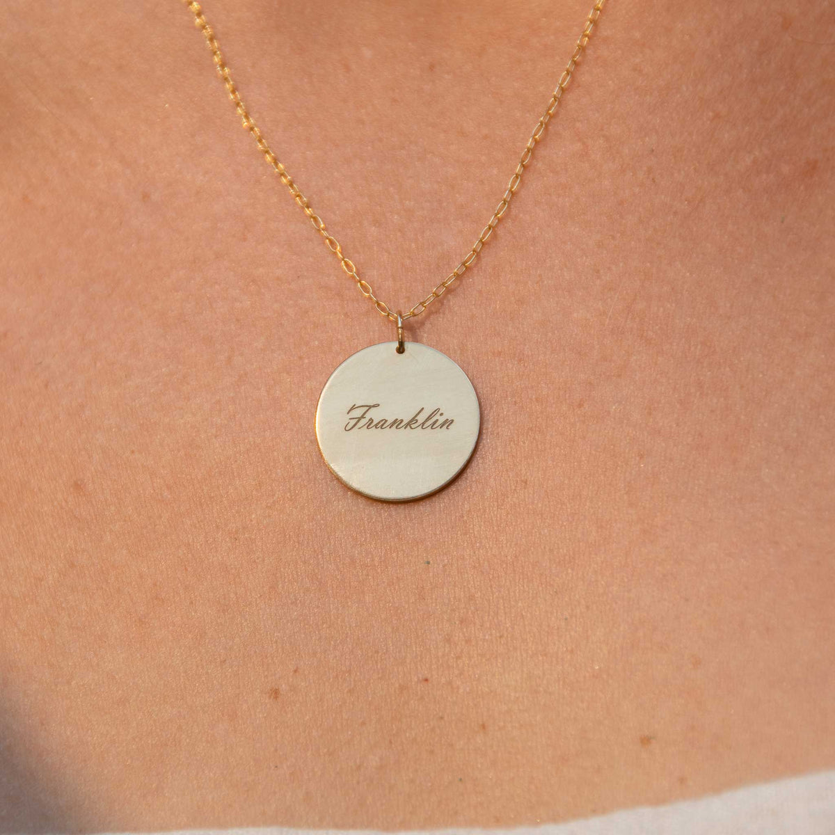 A close up of the Franklin engraved pendant being worn.