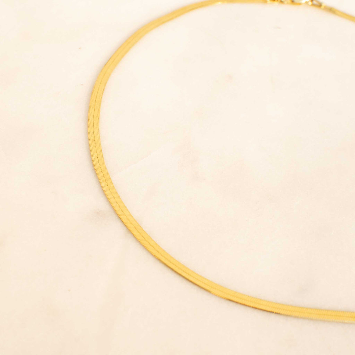 Half of the necklace laid out forming a C shape. 