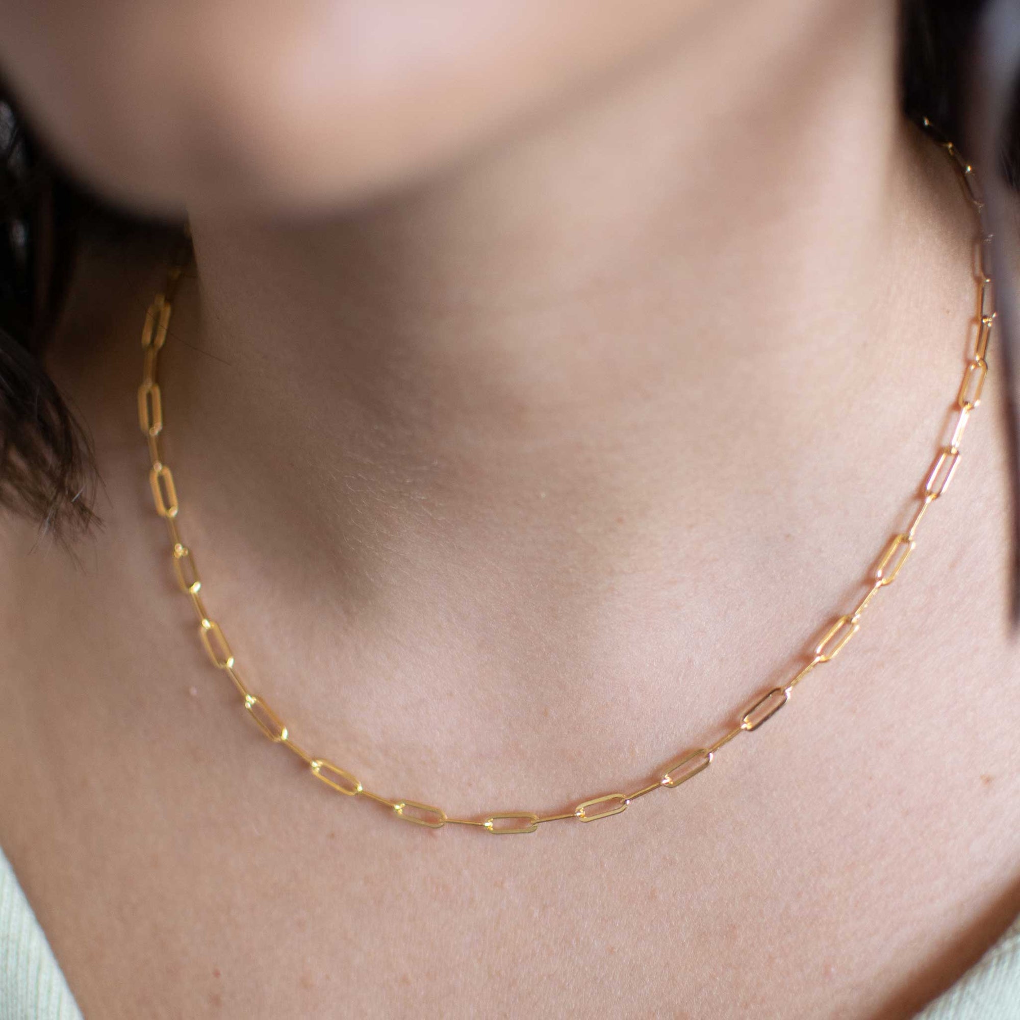 Close up of the gold bold link necklace being worn by a woman.