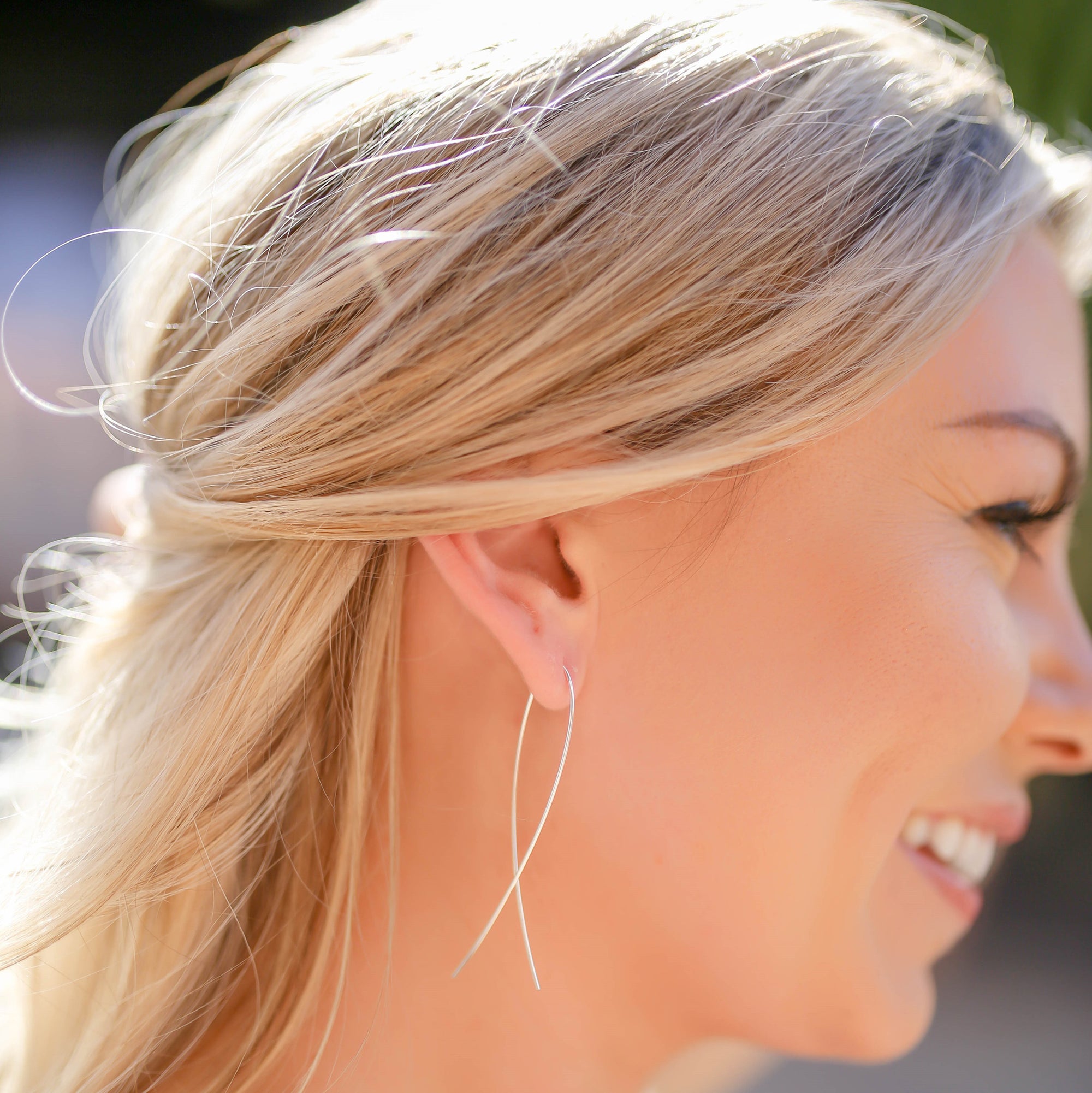Blonde model wearing 925 Sterling Silver fish shaped threader earrings