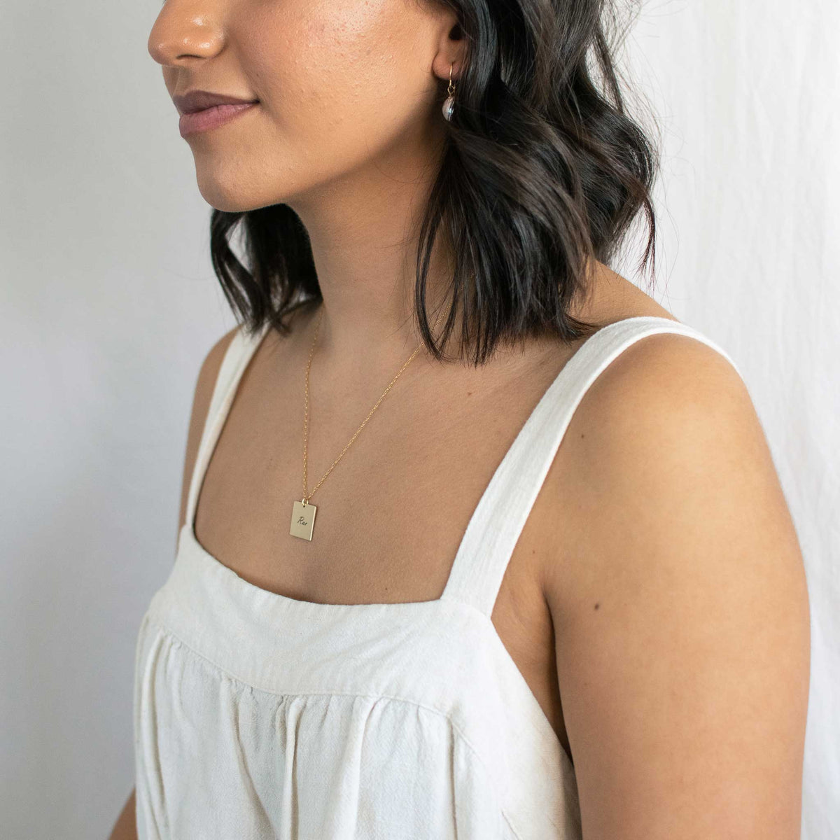 Woman wearing the square necklace.